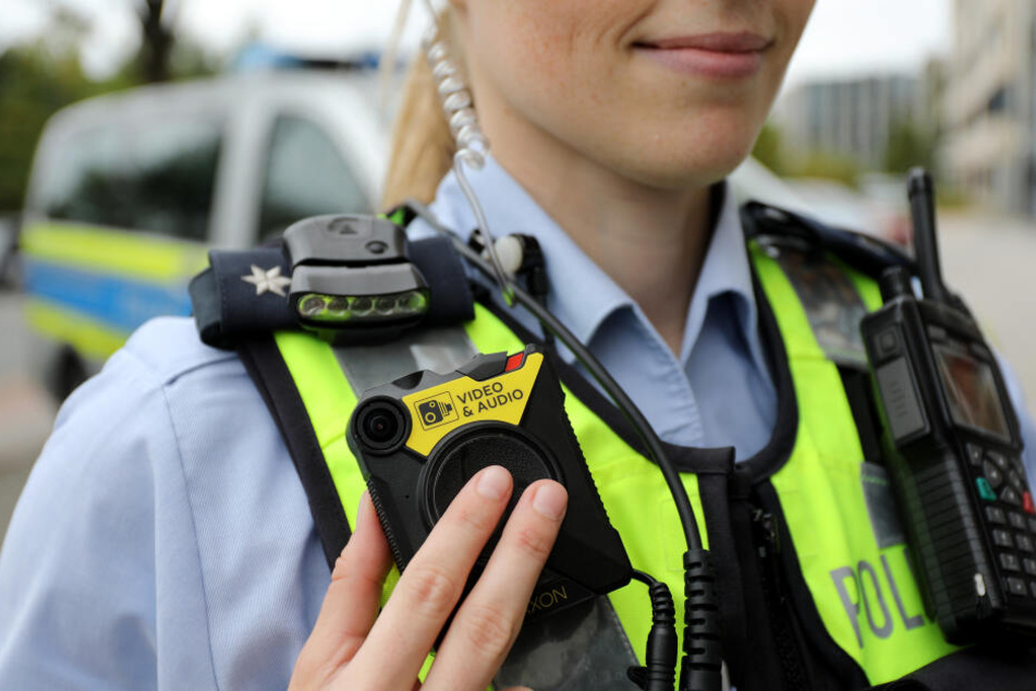 Eine Polizistin der Streifenpolizei führt eine Bodycam vor.