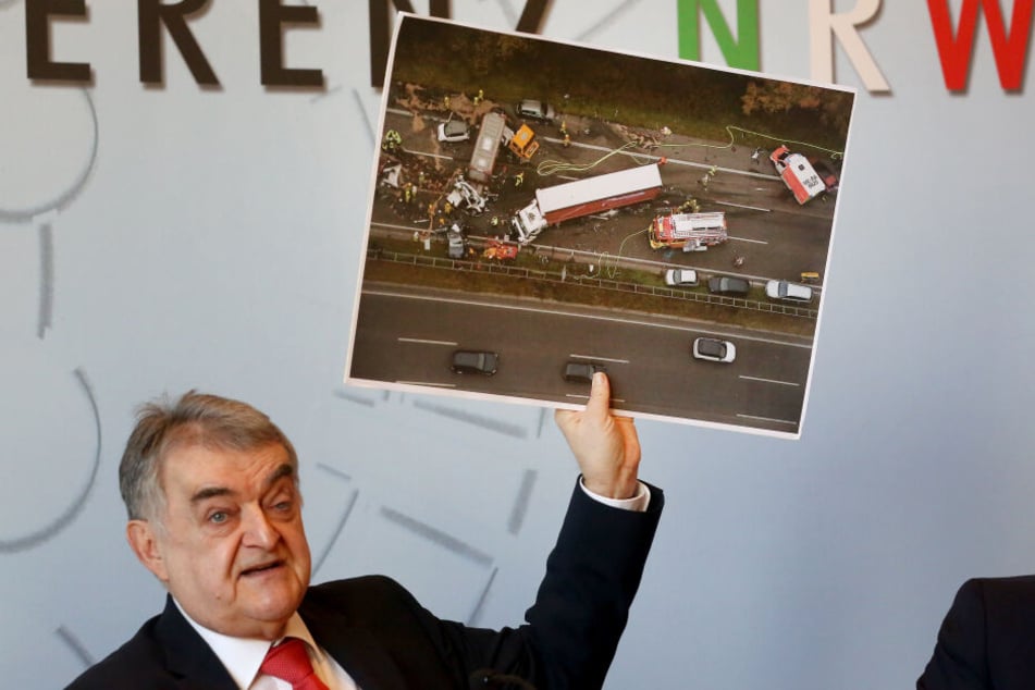 Der nordrhein-westfälische Innenminister Herbert Reul (CDU)zeigt während der Pressekonferenz das Foto eines schweren Verkehrsunfalles mit einem LKW.