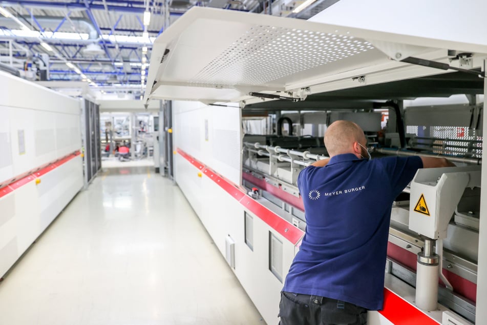 Ein Mitarbeiter richtet die zwölf Meter langen Laminatoren am neuen Sitz des Solarmodul-Herstellers Meyer Burger ein.