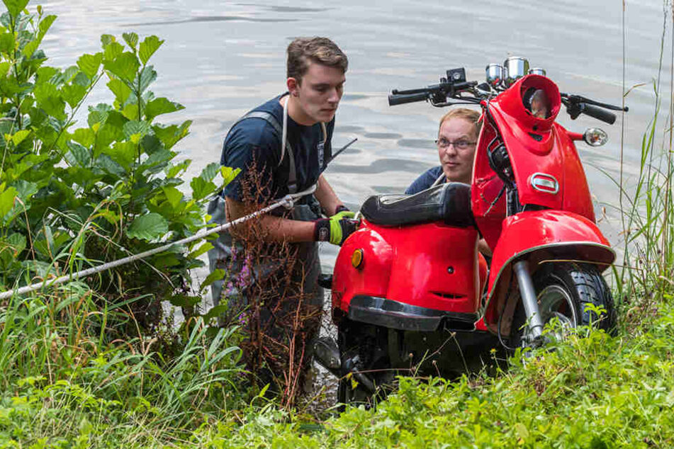Feuerwehrmänner bringen das versenkte Diebesgut an Land.