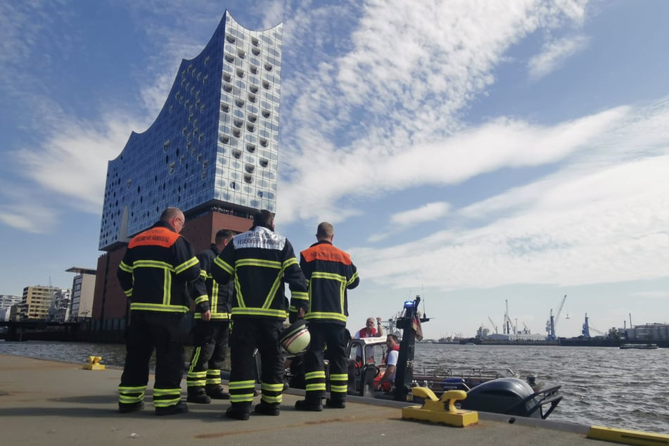 Einsatzkräfte der Feuerwehr und der Polizei stehen an der Kehrwiederspitze nahe der Hamburger Elbphilharmonie.