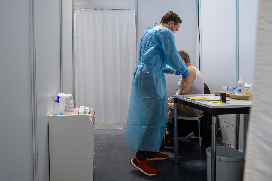 Ein Arzt verabreicht im Impfzentrum der Messe Magdeburg einem Senior eine Impfung gegen das Coronavirus. Ärzte warnen davor, zu schnell Lockerungen vorzunehmen.