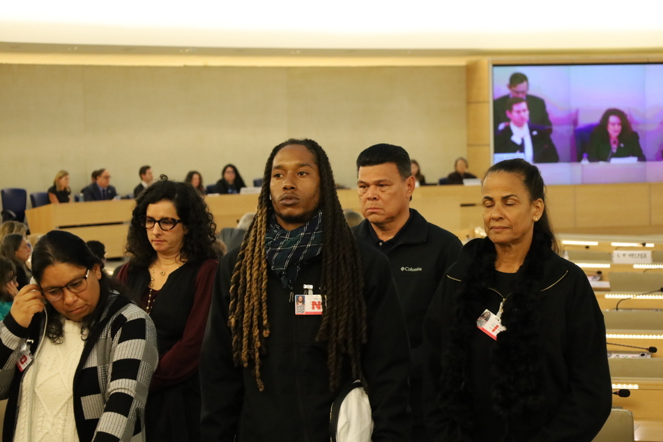 Start With Dignity delegation members rise up for a silent protest as US Ambassador Michele Taylor delivers final remarks before the United Nations Human Rights Committee.