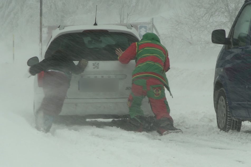 Bitte einmal kräftig schieben: Etliche Autos steckten im eisigen Schnee fest.