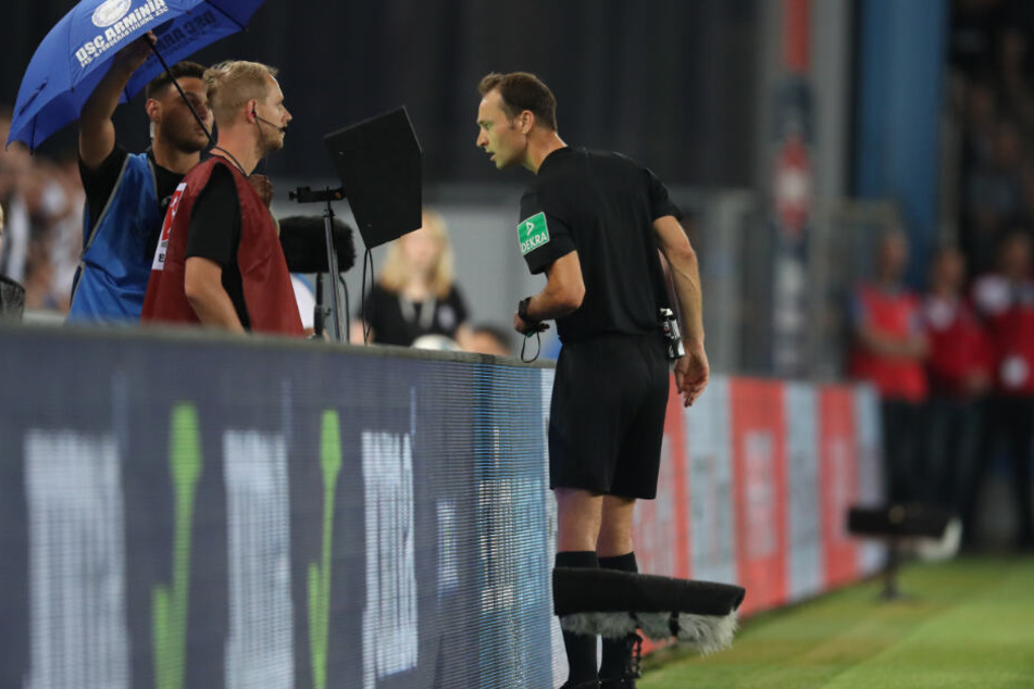Schiedsrichter Bastian Dankert schaut sich eine strittige Szene selbst am Bildschirm an.