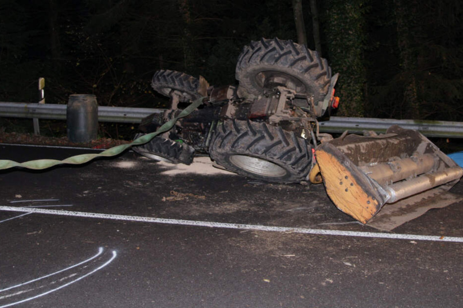 Der Traktor hat sich überschlagen und liegt auf der Straße.