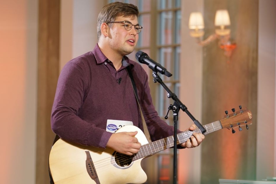 Mit Gitarre begleitet sich Peter Rossow, der in seiner Heimat auch gerne auf der Straße und in Einkaufspassagen singt.