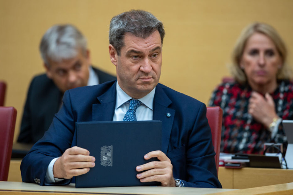 Markus Söder (CSU), Ministerpräsident von Bayern, hält die Regierungserklärung bei der Plenarsitzung im bayerischen Landtag in den Händen.