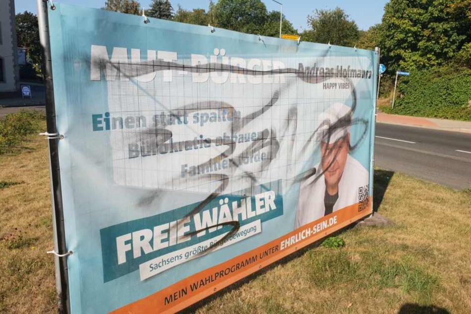 Ein beschmiertes Plakat von Andreas Hofmann (Freie Wähler) in Freital.