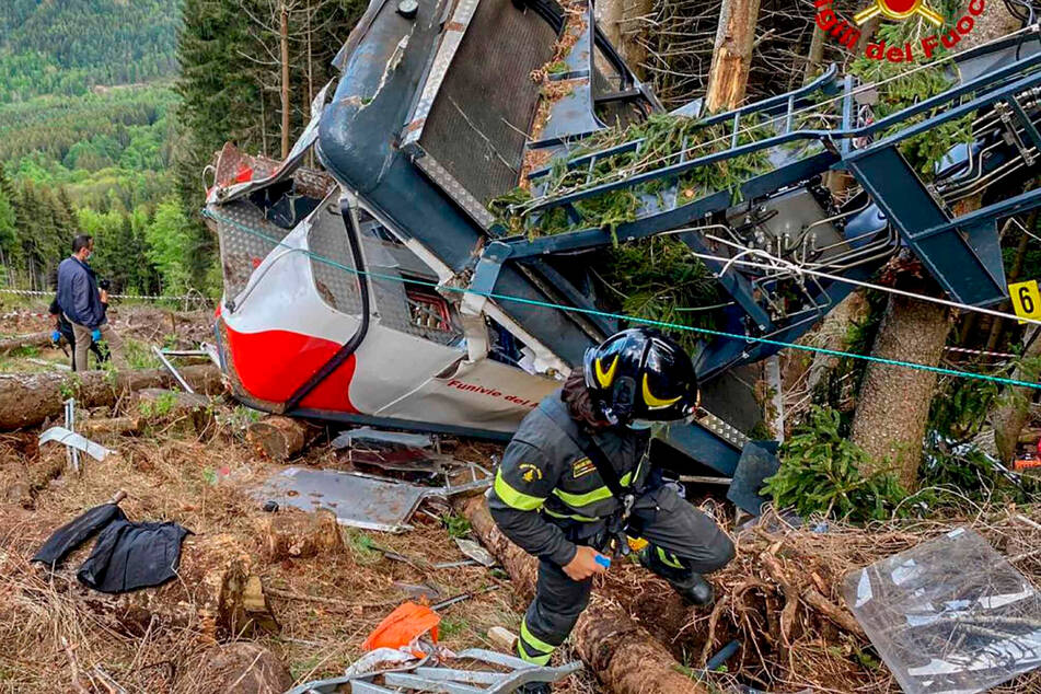 Stresa: Rettungskräfte arbeiten am Wrack der abgestürzten Gondel, die in einem Waldstück liegt.