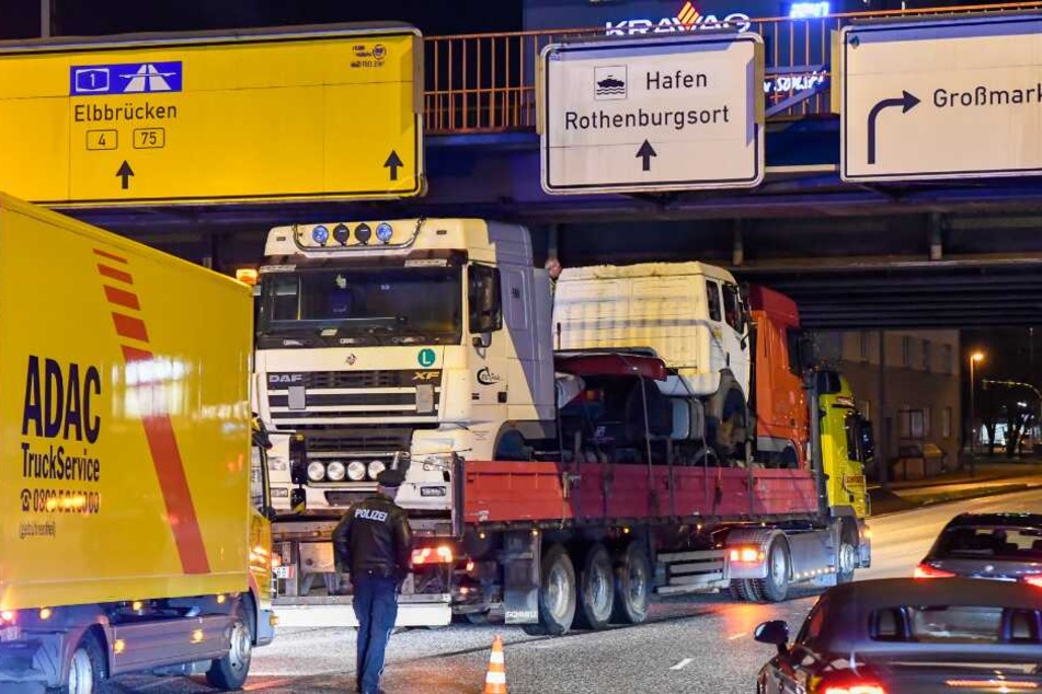Ein Polizist steht vor dem feststeckenden Laster.