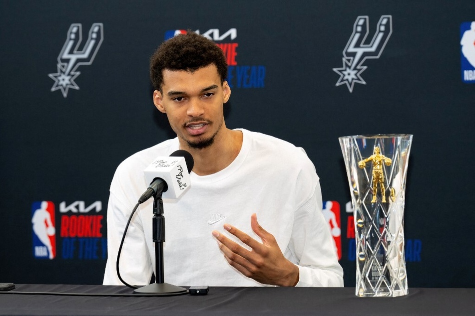 The San Antonio Spurs' Victor Wembanyama speaks to the press after receiving his 2023-24 NBA Rookie of the Year trophy.