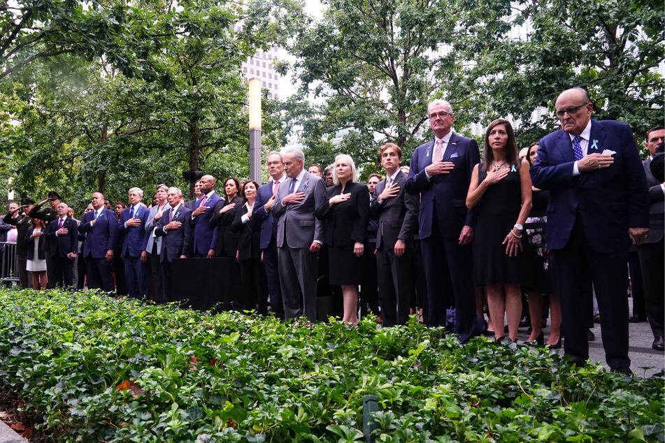 Rudy Giuliani (far r) attended the memorial event on Monday alongside other prominent politicians but blamed the vice president's presence for his early departure.