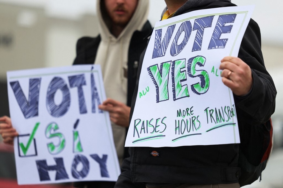 Amazon Labor Union supporters on Staten Island hold signs encouraging workers to vote "yes" for the union.