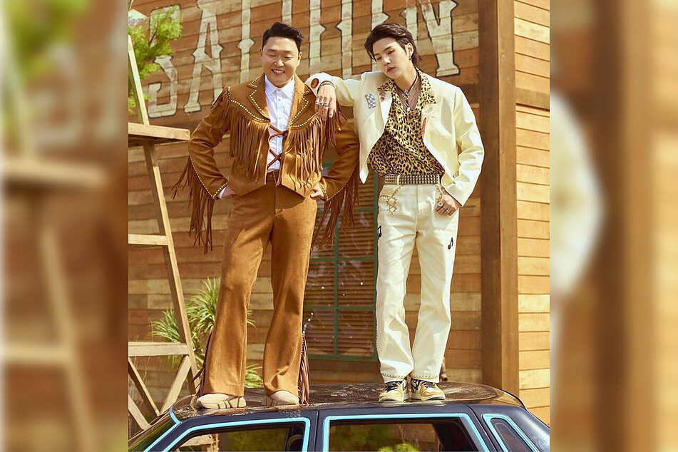 PSY (left) and SUGA of BTS hang out on set for the That That music video.
