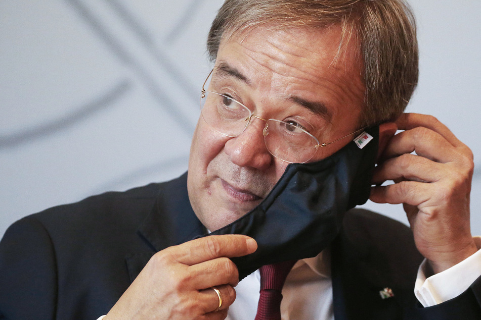 NRW-Ministerpräsident Armin Laschet (59) nimmt bei einer Pressekonferenz seine Maske ab.