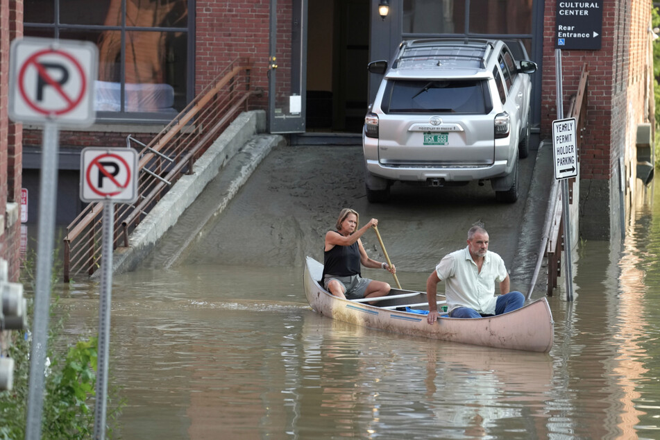 Anwohner in der überfluteten Stadt bewegen sich per Kanu fort.