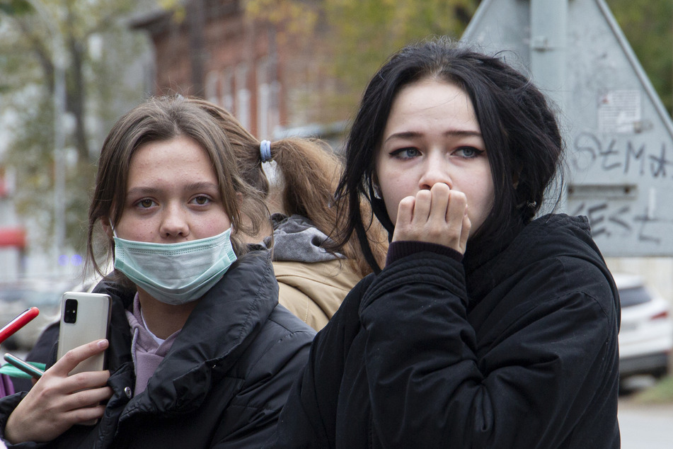 Zwei sichtlich schockierte Studentinnen warten in der Nähe der Staatlichen Universität Perm.