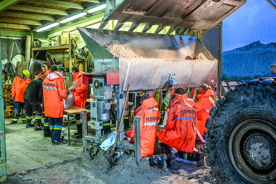 Einsatzkräfte von Feuerwehr und THW befüllen Sandsäcke: Der Landkreis Günzburg hat den Katastrophenfall ausgerufen.