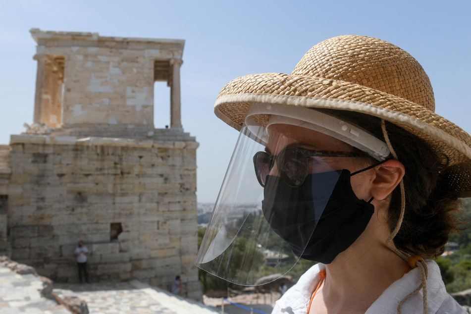 Eine Mitarbeiterin der Athener Akropolis trägt einen Mund- und Gesichtsschutz. (Archivbild)