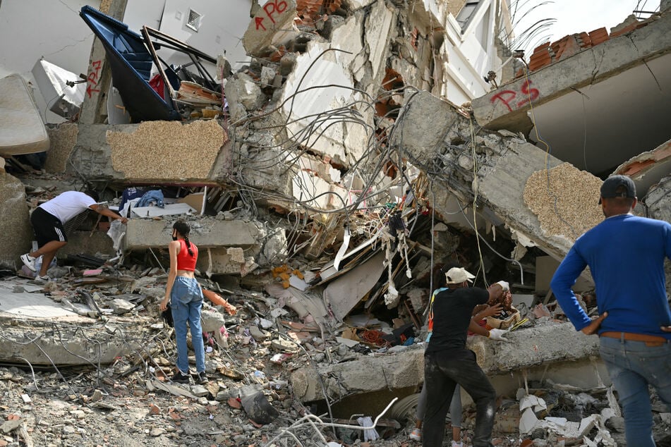 Locals attempt to find belongings at the site of a collapsed building in Caraballeda, La Guaira state, Venezuela, on July 2, 2026.