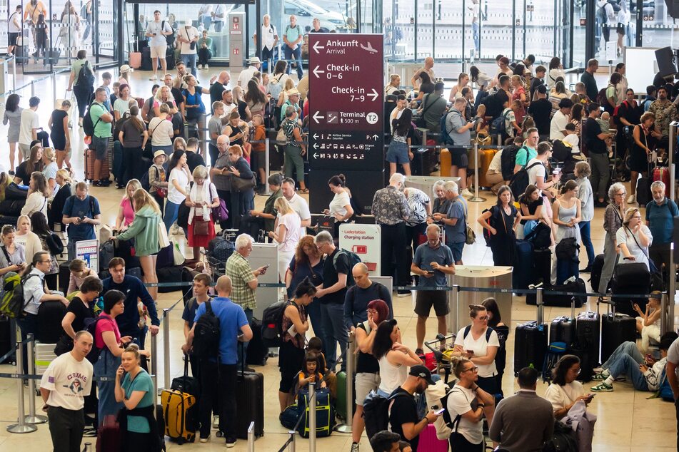 Zahlreiche Fluggäste am Hauptstadtflughafen in Berlin müssen vor den Check-in-Schaltern warten.