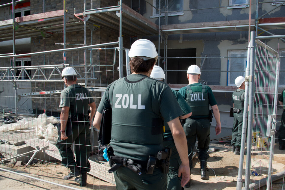 Zollbeamte betreten bei einer Razzia gegen Schwarzarbeit eine Baustelle. (Symbolbild)