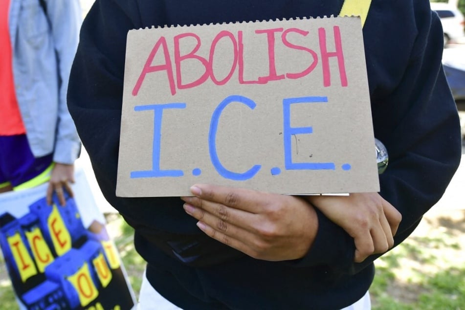 An immigrants' rights activist holds a sign reading "Abolish ICE" during a protest against deportations in Los Angeles, California.