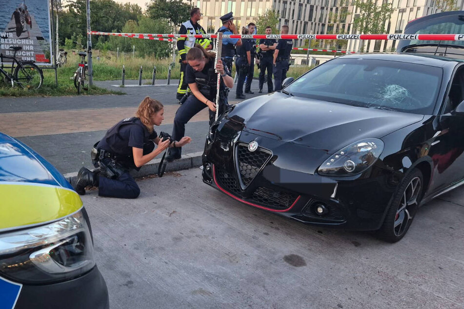 Zwei Polizistinnen untersuchen die Schäden an dem Unfallwagen.