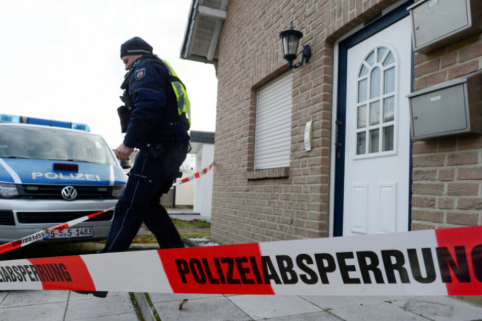 Ein Polizist verlässt ein Haus. (Symbolbild)