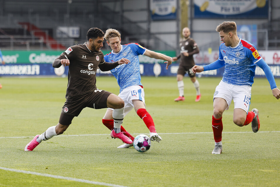 FCSP-Edeltechniker Omar Marmoush (l.), im Zweikampf mit Kiels Johannes van den Bergh (M.) und Simon Lorenz (r.). Die beiden Teams lieferten sich von Beginn an eine hochintensive Partie.