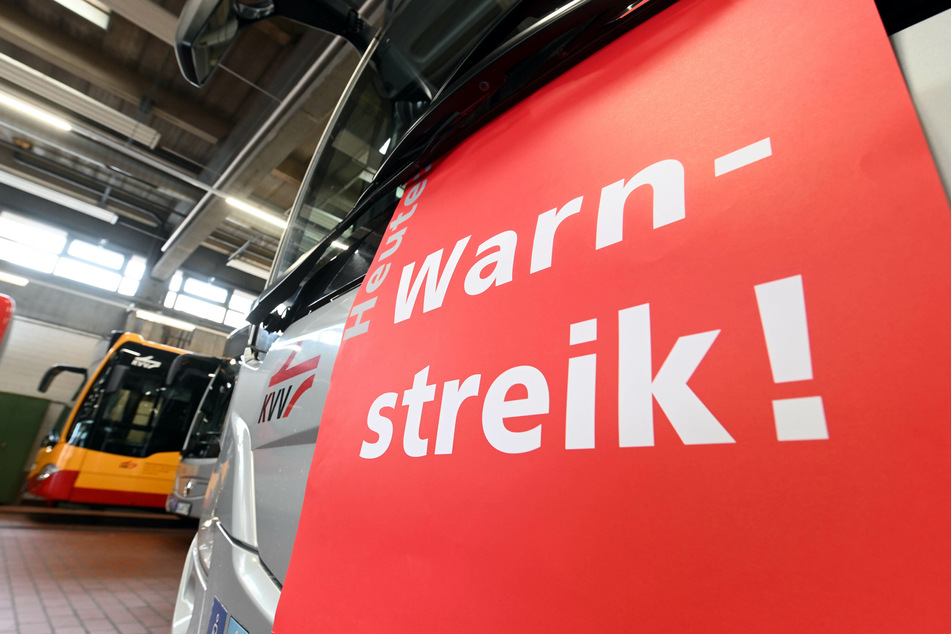 An einem Bus hängt ein Plakat mit der Aufschrift "Warnstreik".