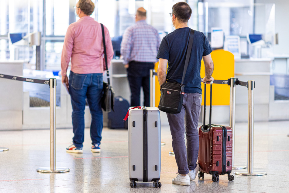 Niedersachsen: Fluggäste stehen im Flughafen Hannover-Langenhagen am Check-in.