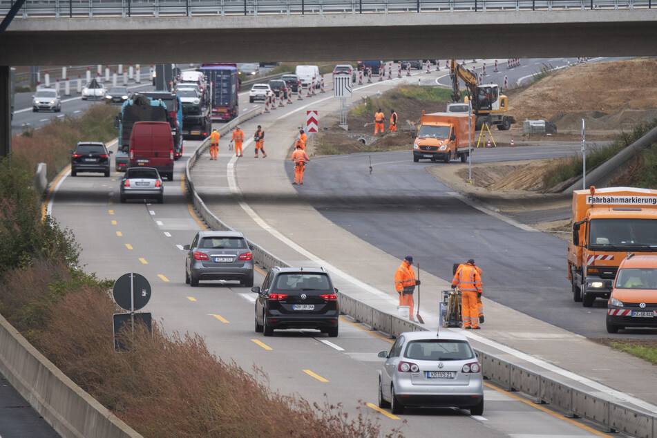 Bauarbeiter stehen in einer Baustelle auf der Autobahn A7.