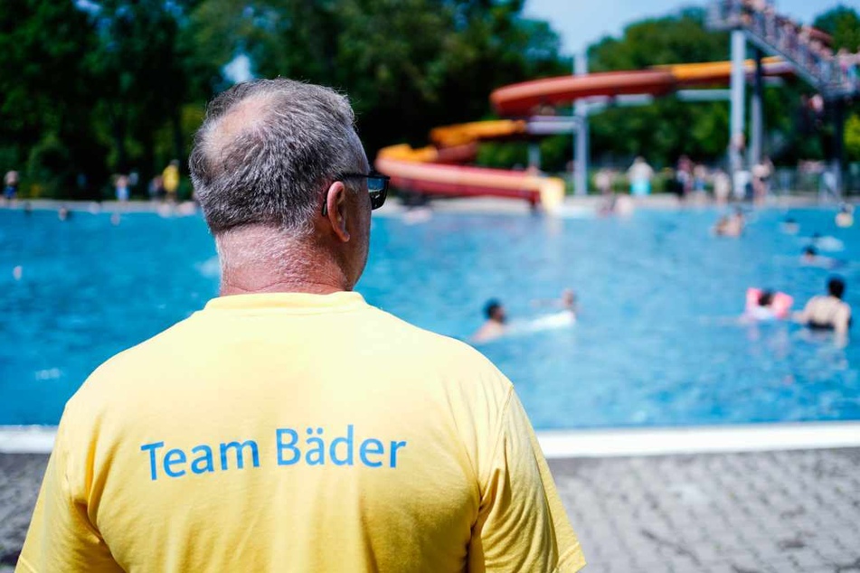 Mannheim: Ein Bademeister steht im Herzogenriedbad vor einem Schwimmbecken mit Wasserrutsche.