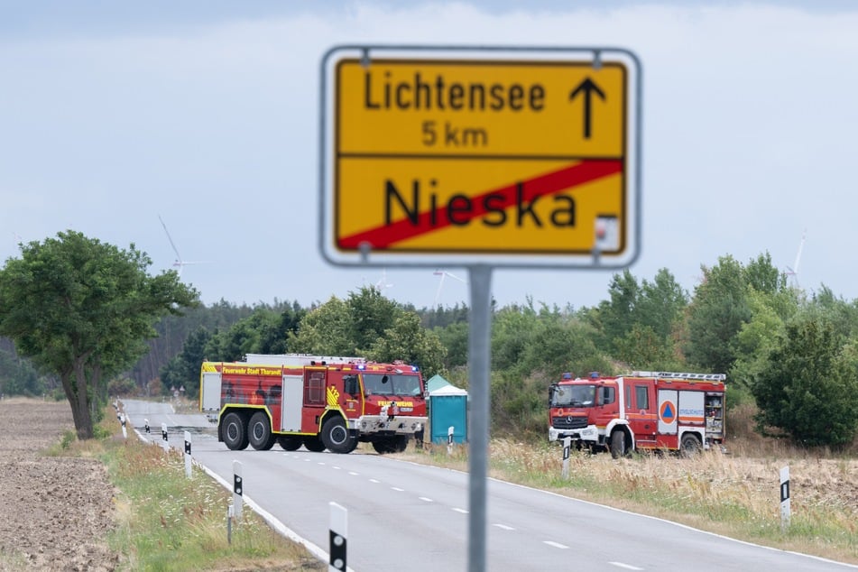 Einsatzfahrzeuge der Feuerwehr stehen anlässlich des Waldbrand in der Gohrischheide an einer Einsatzstelle.