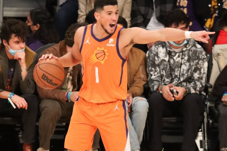 Suns guard Devin Booker went down with a hamstring injury, late in the second quarter against the Warriors.