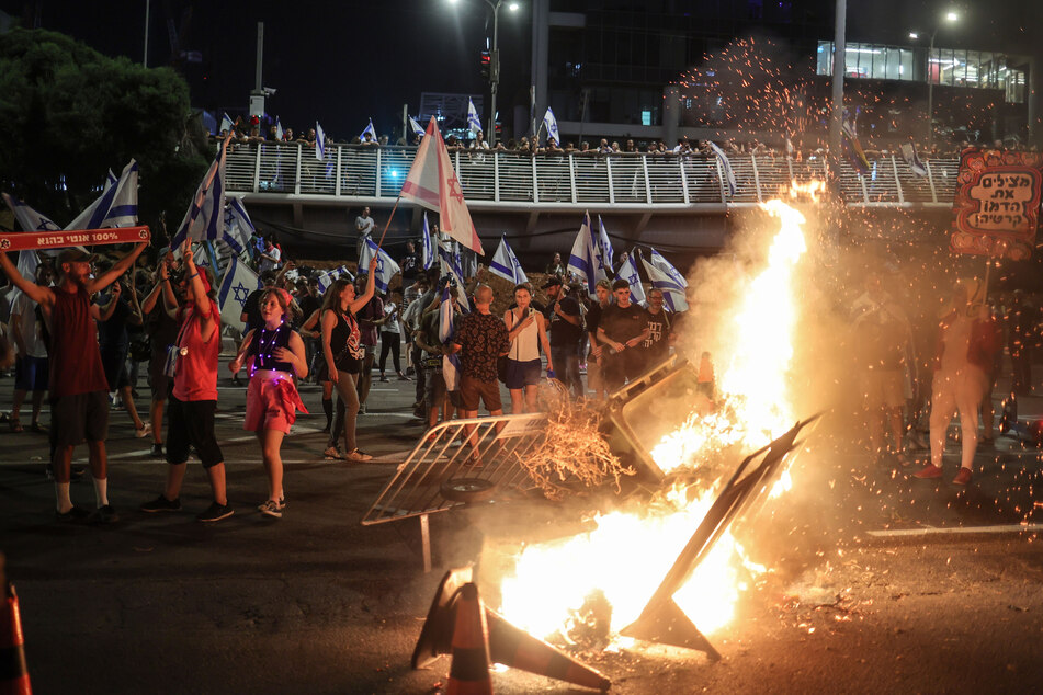 Demonstranten in Tel Aviv verbrennen bei einer Straßenblockade während einer Protestaktion gegen die israelische Regierung Gegenstände.