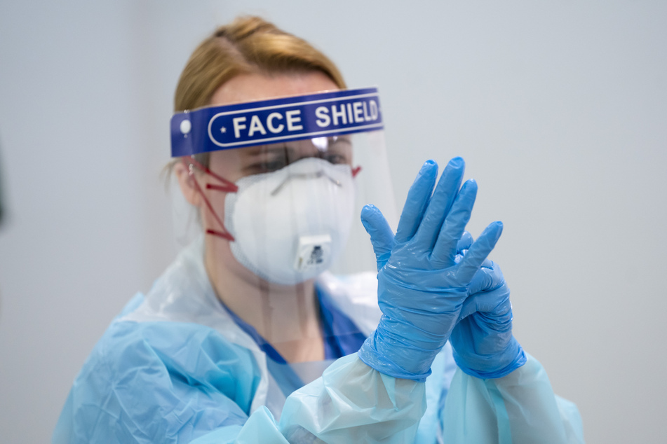Eine Mitarbeiterin erhält im Nightingale-Krankenhaus Nord-West eine Schulung über das An- und Ablegen von Schutzkleidung, um eine Infektion oder Übertragung des Coronavirus zu vermeiden.