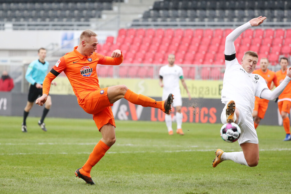 Aues Florian Krüger (21, l.) trifft gegen Sandhausens Aleksandr Zhirov zum 1:1-Ausgleich.