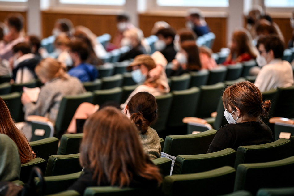 Studenten sitzen im Hörsaal ihrer Universität. Präsenz-Veranstaltungen sollen im kommenden Wintersemester in NRW wieder zur Regel werden.
