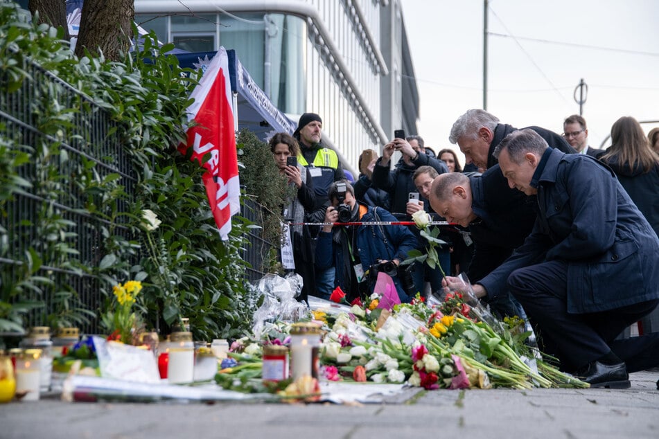 Bundeskanzler Olaf Scholz (SPD), Münchens Oberbürgermeister Dieter Reiter (SPD) und Verkehrsminister Volker Wissing (parteilos) (l.-r.) legen weiße Rosen an der Stelle nieder, wo am 13. Februar ein Auto in eine Ver.di Demonstration gerast war.