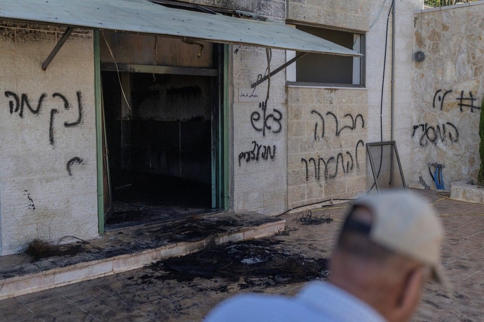 Hebrew graffiti reading "nekama" or "revenge" is pictured on the wall of a burned mosque in the Israeli occupied West Bank village of Jiljliya on June 17, 2026.