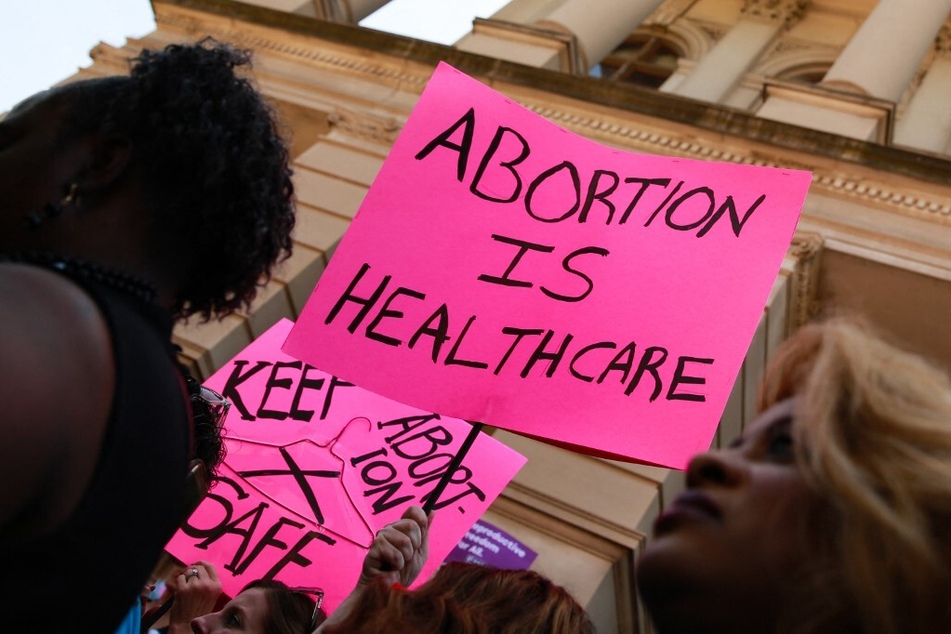 People hold signs protesting the passage of an abortion ban at the Georgia State Capitol building on May 21, 2019.