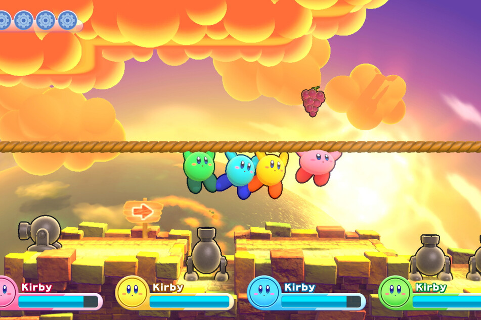 Hier hangeln sich gleich vier Kirbys über einen mit Kanonen gespickten Abgrund.