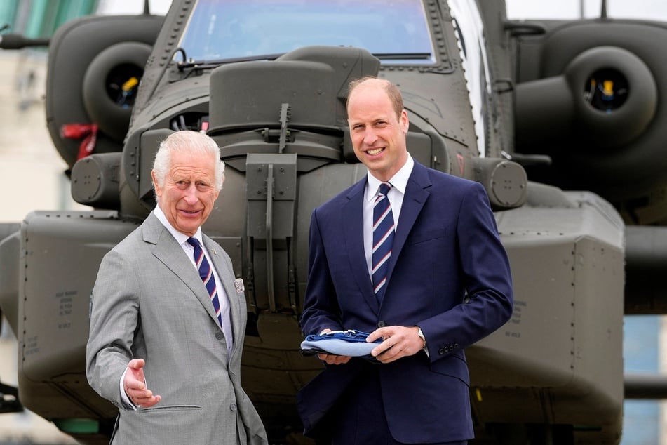 Britain's King Charles III (l.) officially hands over the role of Colonel-in-Chief of the Army Air Corps to Britain's Prince William (r.) in front of an Apache helicopter at the Army Aviation Centre in Middle Wallop, England, on Monday.