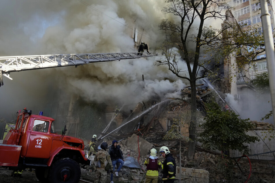 Am 17. Oktober kam erneut zu massiven russischen Angriffen auf Kiew. Feuerwehrleute löschen nach dem Beschuss von Gebäuden durch eine Drohne die verursachten Brände.