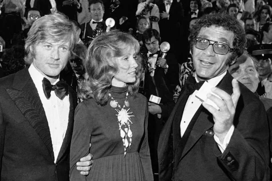 Robert Redford (l.-r.), seine damalige Frau Lola und Regisseur Sydney Pollack bei der Präsentation des Films "Jeremiah Johnson" während der Filmfestspiele in Cannes 1972.