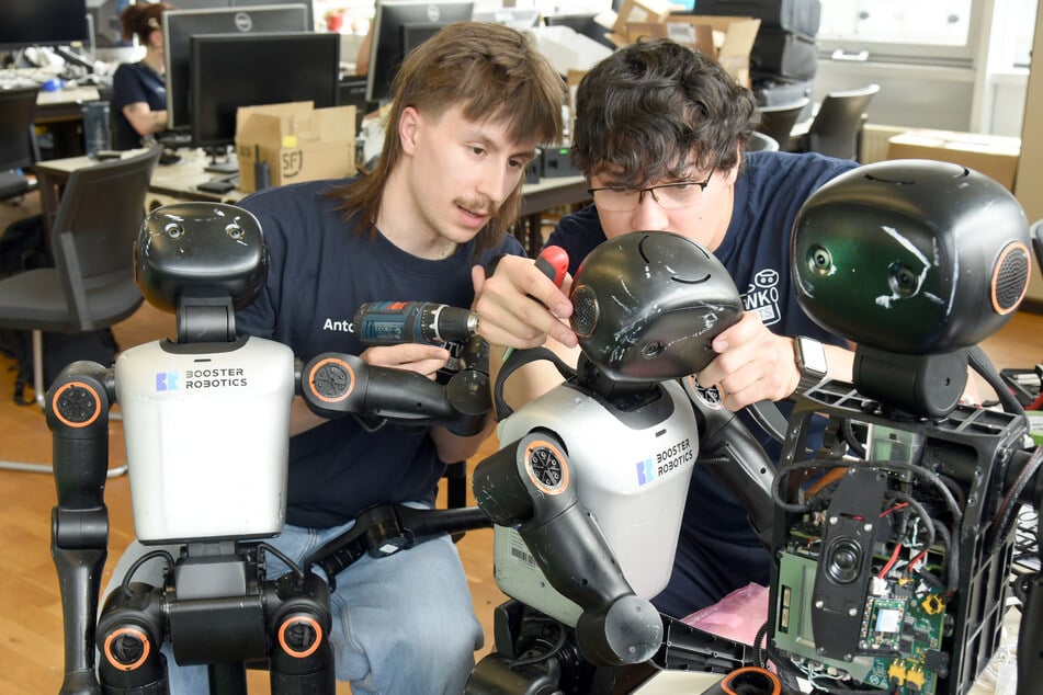 Im Labor vom Roboterfußballteam der HTWK reparieren die Informatikstudenten Anton Makiola (l.) und Erik Behrendt die einen Meter großen und 20 Kilogramm schweren humanoiden Booster K1 Fußballroboter.