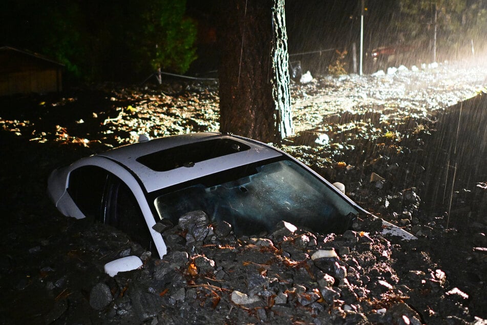 Ein Auto liegt nach einer Überschwemmung im Schlamm begraben.